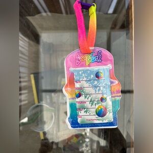 Vintage Lisa Frank luggage tag featuring a colortul dolphin design